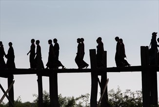 Silhouette of young Buddhist Novices on the U-Leg Bridge at Lake Taungthaman