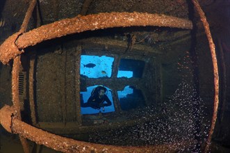 Diver looking at the engine room of the shipwreck Giannis D.