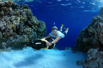Freediver diving with underwater scooter