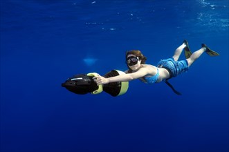 Freediver diving with underwater scooter
