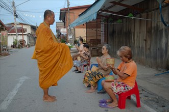 Chiang Khan women offer alms to a monk