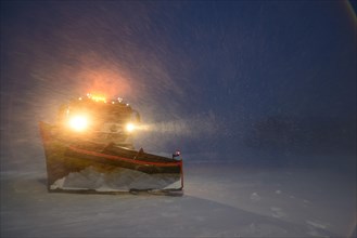 Snowplow in the arctic blizzard during the polar night