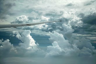 Dramatic cloud formations and the wing of a Boeing 777-300