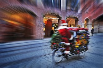 Driving Santa Claus with presents on bicycle