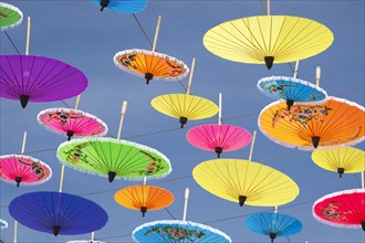 Many colourful umbrellas suspended in mid-air