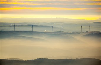 View over the mountains with wind turbines and fog