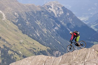 Freeride mountain biker with Liteville riding over cliff edge