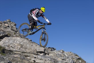 Freeride mountain biker riding over rocks