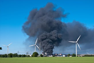 Major fire at waste recycling plant in the industrial area behind wind turbines