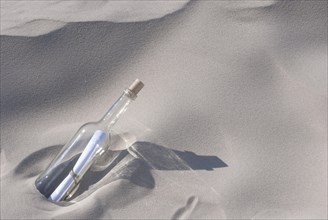 Bottle with a message inside on a sandy beach