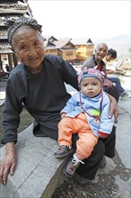 Old Dong woman with grandson with traditional headdress