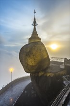 Golden Rock with Kyaiktiyo Pagoda in fog and sunset