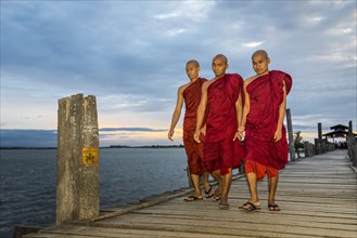 Monks on teakwood bridge