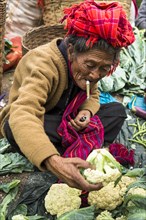 Smoking woman sells vegetables