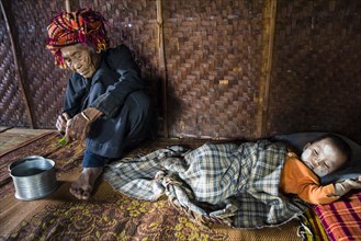Old woman and sleeping child with thanaka paste in the face of hill tribe Pa-O or Pa-Oh or Pao or Black Karen or Taungthu or dew-soo