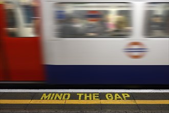 Mind the Gap warning sign on the platform edge of a London underground station
