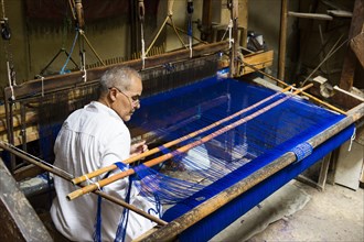 Man working on a loom in the historic centre