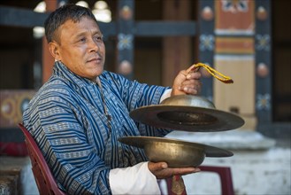 A man with cymbals at a temple festival