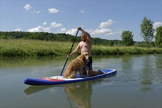 Man with his dog on a stand up paddle board