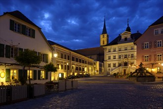 Market place with parish church St. Veit and town hall at dusk