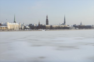 Historical centre on the banks of the frozen Daugava river with Riga Cathedral