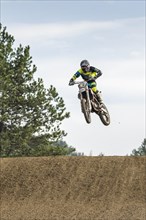 Motorcyclist on a motocross bike jumping through the air