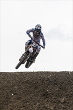 Motorcyclist on a motocross bike jumping through the air