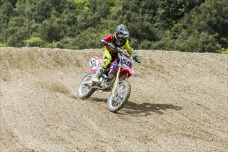 Motorcyclist on a motocross bike riding on a dirt track