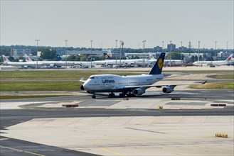 A Boeing 747 of the airline Lufthansa is moving on the ground of Frankfurt International Airport