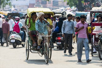 People and cycle rickshaws are moving through the streets of the suburb Old Delhi