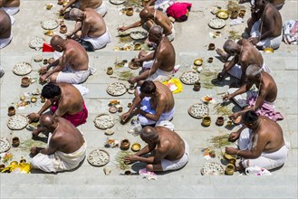 A group of male pilgrims is performing a pooja