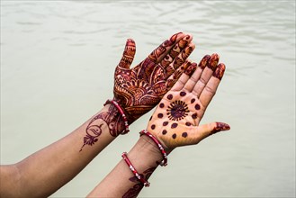 A pair of henna painted hands are displayed at the ghats of the holy river Ganges
