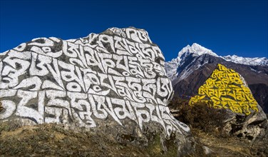Big Mani stone inscribed with the tibetan mantra Om mani padme hum in the background mountain Kangtega