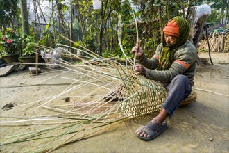 A man is weaving a bamboo basket