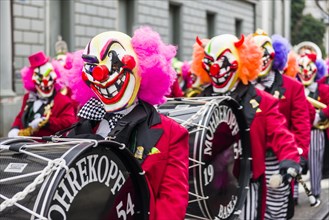 Members of the Gugge marching brass bands wearing fancy dresses and masks at the great procession of the Carnival of Basel