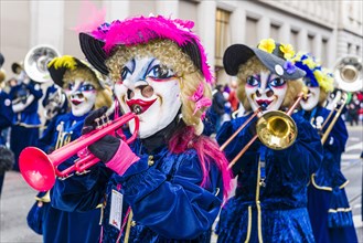 Members of the Gugge marching brass bands wearing fancy dresses and masks at the great procession of the Carnival of Basel
