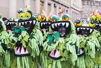 Members of the Gugge marching brass bands wearing fancy dresses and masks at the great procession at the Carnival of Basel