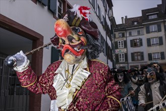 Many different groups of masked people walking through the streets of Basel
