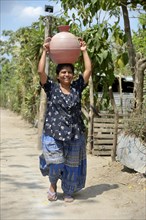 Woman carrying water in a jug on her head