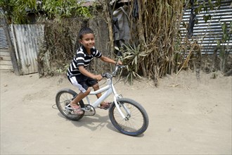 Boy riding his bike from a peace initiative by the police and the Catholic Church in the slum of Colonia Monsenor Romero