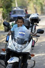 Boy on a police motorcycle at a peace initiative by the police and the Catholic Church in the slum of Colonia Monsenor Romero