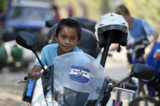 Boy on a police motorcycle at a peace initiative by the police and the Catholic Church in the slum of Colonia Monsenor Romero