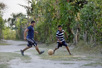 Teenagers playing football on a soccer ground