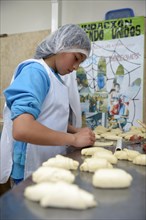 Girl kneading dough in bakery