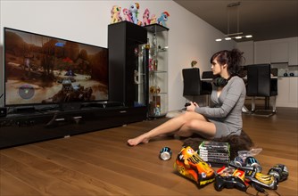 Young woman gaming on a Playstation in the living room