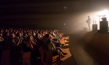 Auditorium and lit stage with live performance by the Irish musician and songwriter Damien Rice at the Blue Balls Festival