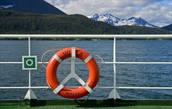 Lifebuoy on ferry Volda in front of a fjord landscape