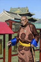 Old man in traditional Mongolian costume with Buddhist prayer beads in left hand