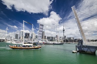 Yacht reaching the Auckland Harbor crossing an open drawbridge