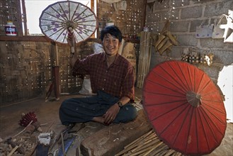 Local man with finished umbrellas in an umbrella factory